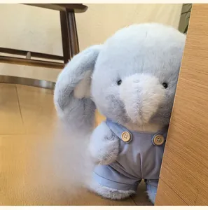 Close-up of plush blue elephant in corduroy overalls with wooden buttons and soft texture