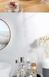 Waterproof white skincare bottles set with gold lids on a black tray in bathroom
