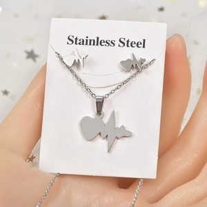 Macro shot of silver stainless steel heart necklace and earrings set on display card