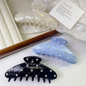 Three premium pearl hair claws with seashell texture in white, blue and black colors