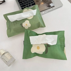 Close-up of green daisy pattern fabric tissue box cover showing texture and stitching
