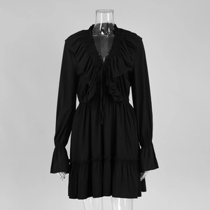 Detailed view of the deep V-neckline with decorative ruffles on this black chiffon dress