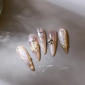 Detail of pink gradient stiletto press-on nails with 3D butterflies and floral art