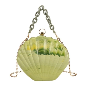 Green shell-shaped acrylic handbag with marble pattern and dual chain straps on white base