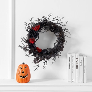 Halloween wreath with black dead branches and dark red roses on white wall decor
