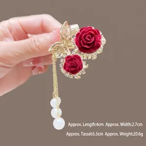 Détail de la pince à cheveux rose velours rouge avec papillon et glands de perles