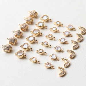 Detailed macro view of gold-plated star, heart, and moon charms with sparkling cubic zirconia