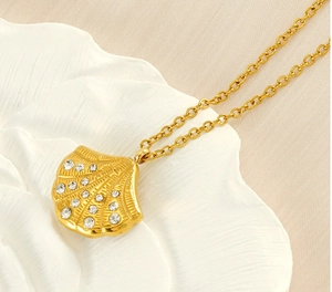 Macro shot of gold-plated shell pendant necklace with white rhinestones on shell tray