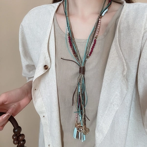 Detail of bohemian multilayer necklace featuring colorful beads and soft cotton tassels