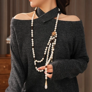 Detail of vintage multilayer pearl necklace with square metal accent and teardrop pendants