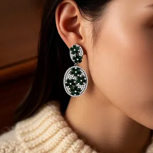 Vintage silver earrings with emerald green zircon flower pendants on model