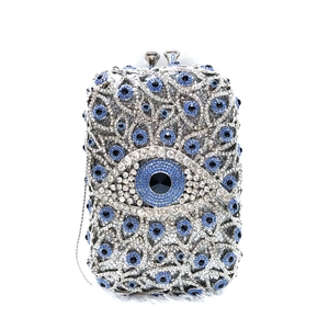 Detailed close-up of crystal evil eye pattern on luxury silver and blue clutch bag