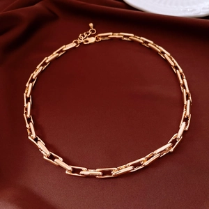 Close-up of golden chunky chain necklace with rectangular links on silk background