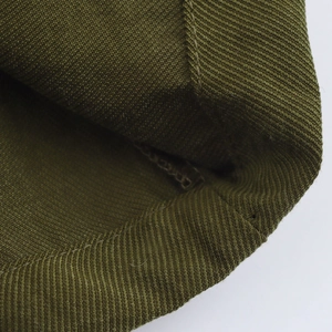 Close-up of military green ribbed fabric texture and professional stitching details