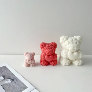 Detailed rose texture on teddy bear candles in pink, red, and white tiered sizes
