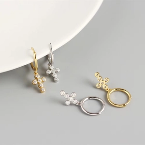 Detail of 925 sterling silver hoop earrings with zircon crosses in gold and silver