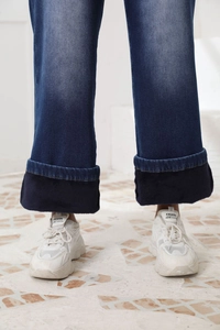 Dettaglio dei jeans dritti a vita alta con calda fodera in pile nero e orlo con risvolto