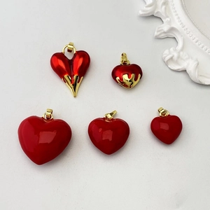 Detailed view of red heart pendants in various sizes with gold melting drip design accents