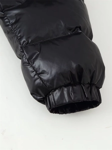 Detail of elastic cuffs on a shiny black hooded puffer jacket for winter wind protection