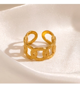 Detail of gold-plated chunky link ring with hammered texture on white silk fabric
