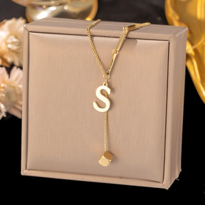 Detailed close-up of golden stainless steel S-letter pendant necklace with cube charm