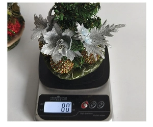 Detailed top view of 80g mini Christmas tree ornament on a digital scale for weight check