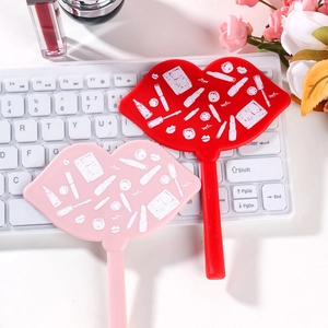 Lip-shaped makeup mirrors in red and pink colors with cosmetic icons on a keyboard