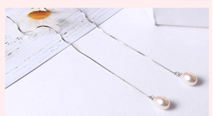 Close-up of S925 silver drop earrings with elegant long chains and white natural pearls