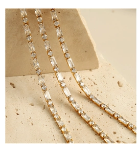 Detail of gold-plated tennis chain featuring alternating baguette and round-cut cubic zirconia