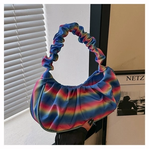 Detailed macro view of the colorful rainbow gradient pleated satin fabric texture on the bag