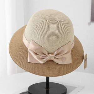Detail of color-block straw sun hat with satin ribbon bow and UV CUT tag on rack