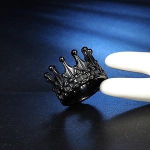Macro shot of black crown ring showing gothic texture held by white mannequin