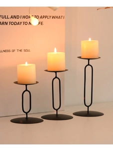 Close-up of matte black metal candle holders with modern minimalist oval design