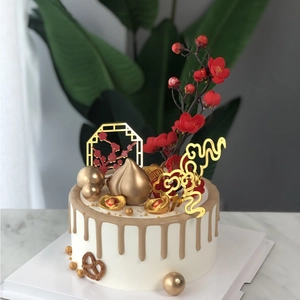 Chinese birthday cake toppers with golden longevity peach, plum blossoms and Fu ingot