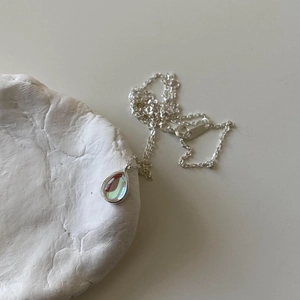 Detailed view of iridescent teardrop pendant on minimalist 925 silver chain