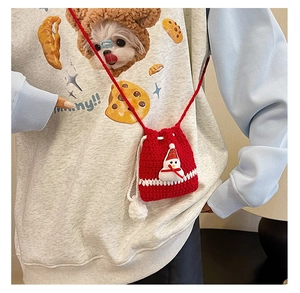 Detail of hand-crocheted red pouch with 3D snowman, drawstring closure and pom-poms