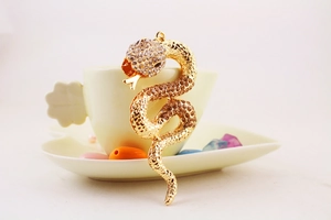Macro shot of creative golden snake keychain set with sparkling white and brown rhinestones