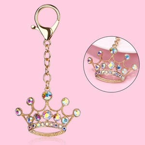 Golden crown keychain with colorful rhinestones on a pink background for women and girls