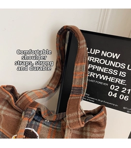 Close-up of wool plaid tote bag showing thick texture, durable handle, and fine stitching