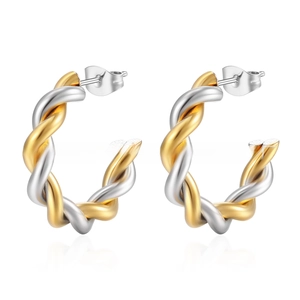 Macro detail of twisted hoop earrings in two-tone gold and silver stainless steel finish