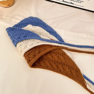 Retro knitted crochet headscarf with blue and white stripes on a neutral fabric background