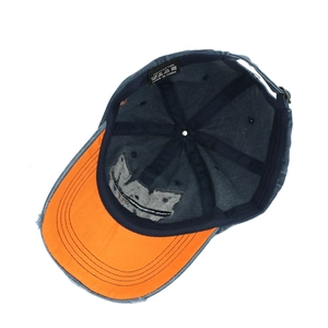 Detail view of denim baseball cap interior with orange brim and 100% cotton wash label