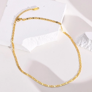 Golden stainless steel mariner chain necklace displayed on minimalist white stone
