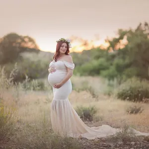 Close-up of off-shoulder maternity dress with chiffon tail for photography in sunset