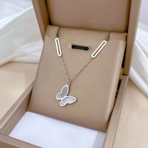 Elegant silver butterfly pendant necklace in a beige jewelry box with pearl inlay
