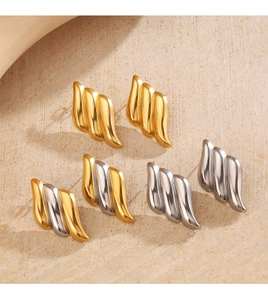 Détail de boucles d'oreilles ondulées en acier inoxydable en or, argent et bicolore