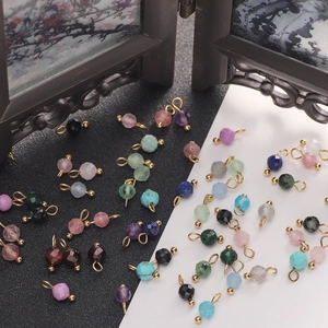 Close-up of assorted 4mm faceted natural stone pendants with gold metal rings for DIY