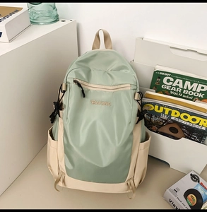 Detailed view of mint green and beige nylon backpack in an aesthetic lifestyle setting