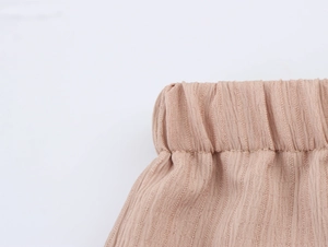 Vue détaillée de la taille élastique d'un pantalon marron clair à texture gaufrée