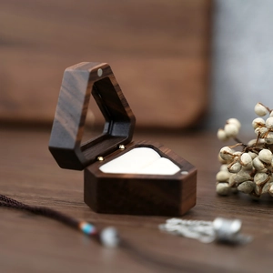Detail of a vintage hexagonal wooden jewelry box with white ring slot and natural dried berries